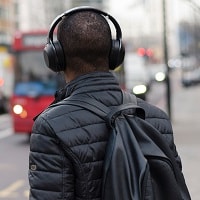 man wearing noise canceling headphones on road