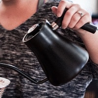 woman pouring from electric kettle