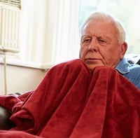Old man using a red blanket