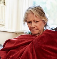 Old woman using a red blanket