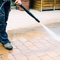 man washing the floor with a pressure washer