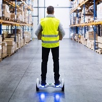 man riding a hoverboard in the warehouse