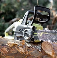 Electric chainsaw on the wooden log