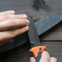sharpening survival knife on a stone